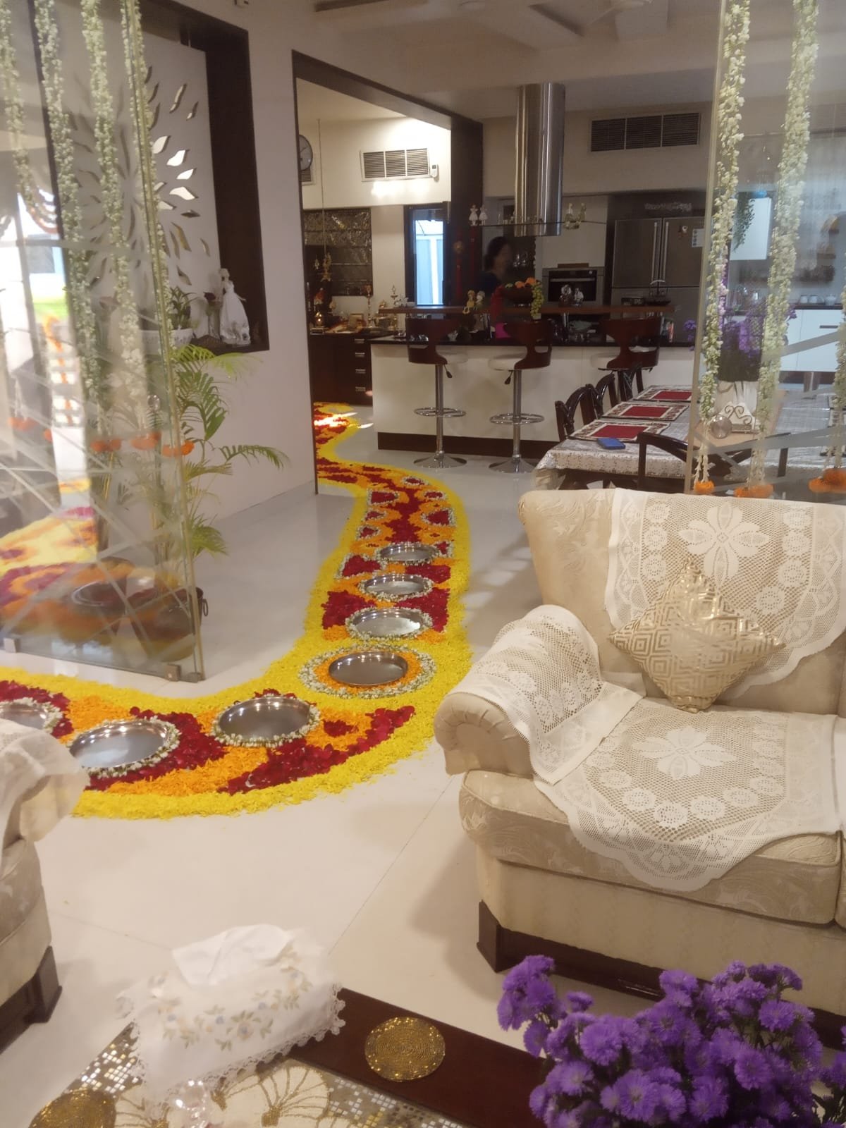 Home event setup decorated with floral rangoli and hanging garlands