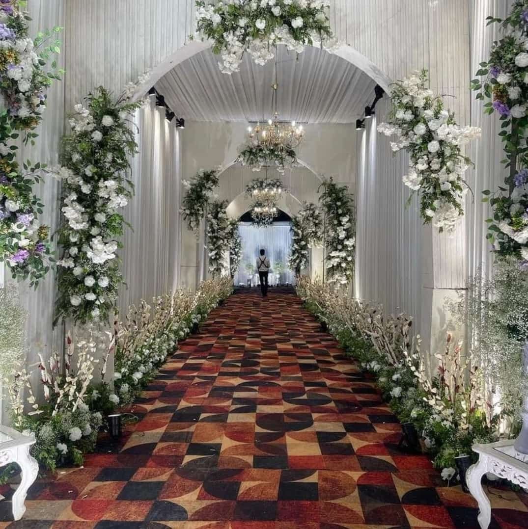 Wedding walkway decorated with white floral arches